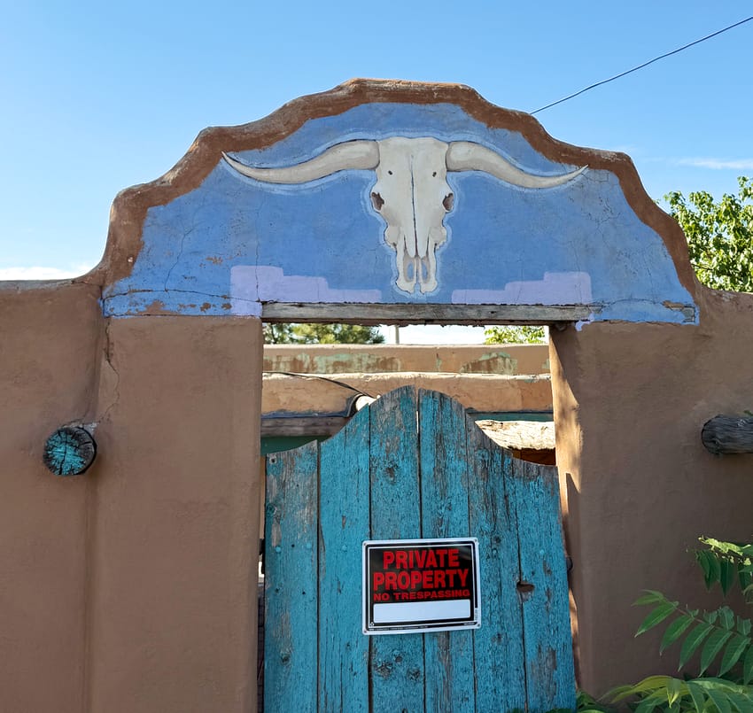Santa Fe adobe gate with longhorn skull painting