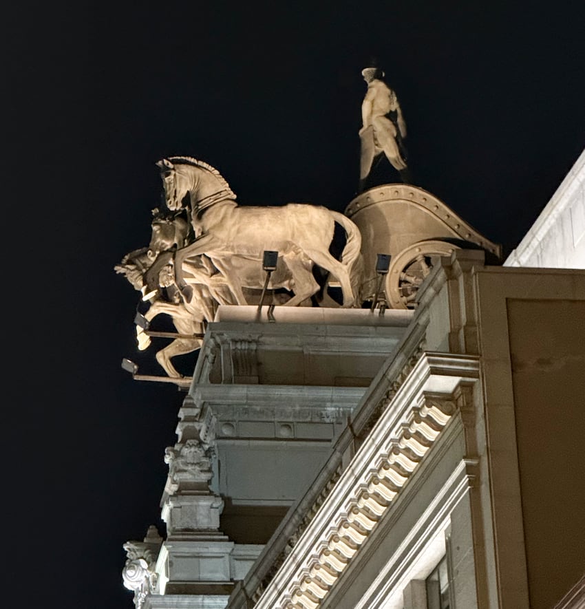horses pulling chariot sculpture atop a building in Madrid