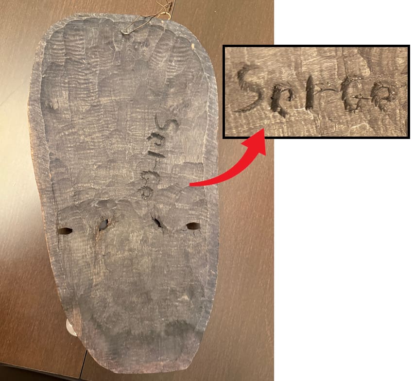 signed back of wood mask, signature reads Serge